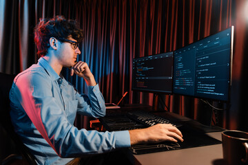 IT developer thinking online software development information coding on pc screen at side view, working on design new program for latest version application on website at neon modern office. Gusher.