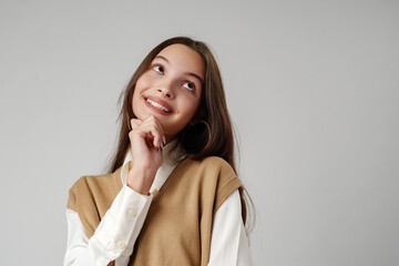 Wall Mural - Young Woman Wearing a Brown V-Neck Sweater Vest Over a White Shirt and Beige Pants