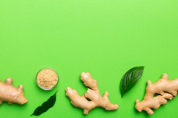 Wall Mural - Finely dry Ginger powder in bowl with green leaves isolated on colored background. top view flat lay