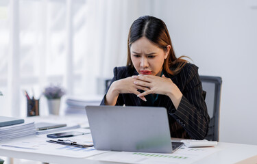 Portrait of tired  business asian woman sitting at a work. documents tax laptop computer in office. Sad, unhappy, Worried, Depression, or overworked, failure employee life stress concept	