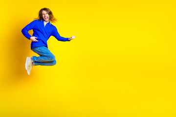 Wall Mural - Photo of cheerful optimistic crazy man wear stylish blue clothes empty space isolated on yellow color background