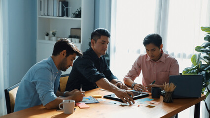 Wall Mural - Group of diverse people sharing idea while writing at sticky notes. Professional smart business team brainstorming idea and planning strategy for startup project while wear casual outfit. Convocation.