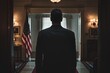 © KP - Man in Suit Standing in a Room with American Flag.