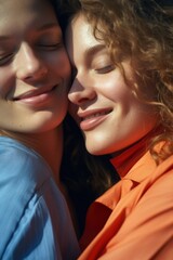 Two young women embracing, smiling, in natural light. Friendly and affectionate atmosphere.