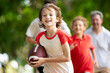 © famveldman - Family playing American football. Kids play rugby