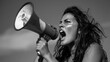 © furyon - fierce woman with flowing dark hair shouting into megaphone highcontrast black and white image conveys power urgency and call to action