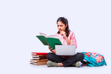 Wall Mural - Indian asian pretty young female student studying sitting on white backgrounds