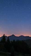 Wall Mural - bright day to starry night sky in mountains, vertical time lapse of evening dusk