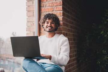 Wall Mural - Photo of attractive funny guy wear white sweatshirt sending emails modern device indoors room home house