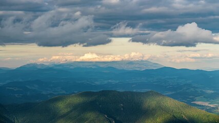 Wall Mural - clouds sky moving fast over green forest mountains landscape time lapse