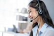 © Wasana - A woman wearing a headset is smiling while talking on the phone