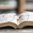 © Анатолий Сав - A pair of round eyeglasses rests on the pages of an open book. Generative AI