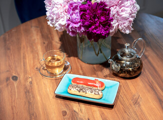 Wall Mural - A plate of two chocolate covered donuts sits on a wooden table next to a tea set