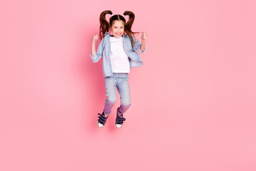 Poster - Full size photo of excited positive lovely small girl dressed denim shirt pants jumping having fun isolated on pink color background