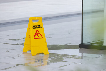 Wall Mural - A yellow caution sign is on the ground