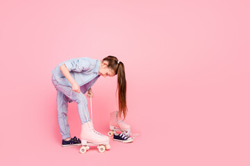 Sticker - Full size photo of positive lovely cute small girl dressed denim pants shirt wear rollers on feet isolated on pink color background