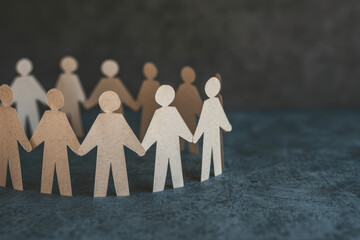Poster - Paper cutout people standing in a circle holding hands, symbolizing community, teamwork, collaboration, and unity on a dark textured background.