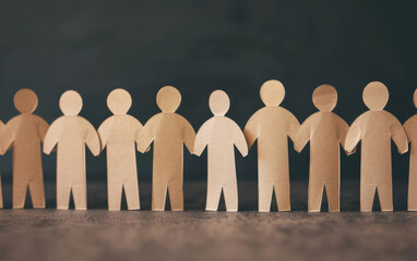 Poster - Close-up of paper human chain cutouts linked together on a dark background symbolizing teamwork, unity, community, and collaboration.