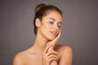 © AK Coop/peopleimages.com - Beauty, skincare and woman touch face in studio for cosmetics, wellness and satisfaction. Dermatology, spa aesthetic and person with eyes closed for health, salon and makeup on gray background