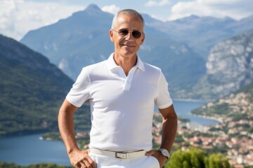 Sticker - Portrait of a glad man in his 50s donning a classy polo shirt while standing against panoramic mountain vista