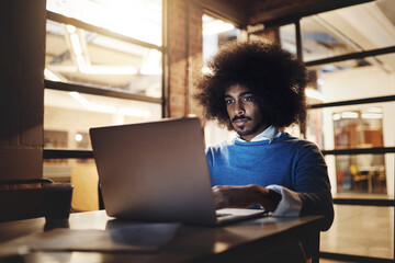 Poster - Night, black man and laptop in office for IT, editing and digital design for company. Male creative, typing and web development in dark with tech, programming and logo creation for small business
