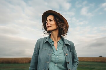 Sticker - Portrait of a blissful woman in her 40s sporting a rugged denim jacket in backdrop of an idyllic countryside