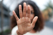 © Centric  - Close-up of African American woman with curly hair holding her hand up in a stop gesture in an urban environment