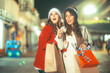 © Marco - Friends having fun watching the lights, wearing winter clothes doing their Christmas shopping, with their bags full of gifts for the holidays, the lights in the background are a giant Christmas tree.
