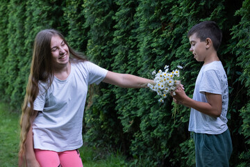 girl with long hair, beautiful girl, hair dyed pink, pink hair, hair, white t-shirt, outdoors, boy with bouquet, daisies, guy gives flowers, emotions