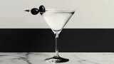  B&W photo of a martini glass w/ olive garnish on rim & black olive garnish on rim