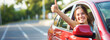 © Andrey_Lobachev - Beautiful girl driver smiles and shows a thumbs up while driving a new car. Concept of buying or renting a new car