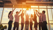 © VK Studio - A team enthusiastically raises their fists in triumph as the sunlight pours in, celebrating success together in an urban office setting.