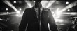 © Kedsaraporn - A silhouette of a singer in a tuxedo, performing on stage with dramatic lighting effects, creating a captivating atmosphere.