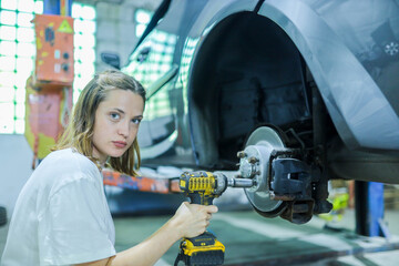 Wall Mural - female auto mechanic repairs car brake system