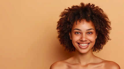 Woman with radiant smile and curly hair posing against a clean beige background, beauty, happy