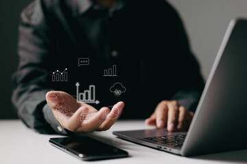 Fototapete - person using a laptop with data icons hovering above their hand, symbolizing the integration of digital technology and data analysis in business.