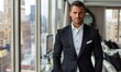 © piai - Handsome Young Man in Full Black 3-Piece Suit Facing the Camera in Luxury Penthouse Office