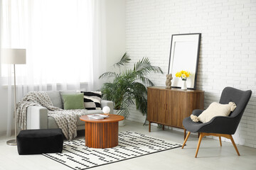 Wall Mural - Cozy sofa with plaid, cushion and coffee table in interior of living room