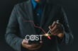 © Nirusmee - Cost reduction concept. Cost Management, Businessman work on company cost saving. The word 'COST' appears as decrease with down arrow. Economy recession, low budget, Effective business, Expense reduce