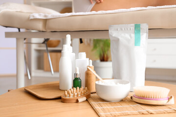 Poster - Anti-cellulite bandage with cosmetic products and massage brushes on table in spa salon, closeup