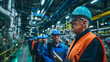 © khonkangrua - Group of industrial workers in protective helmets and vests in a factory, emphasizing workplace safety and teamwork.