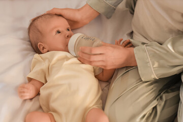 Poster - Mother feeding her little baby in bedroom at night, closeup