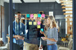 © Hira/peopleimages.com - Group, people and sticky notes on glass for project ideas, planning and schedule management of startup. Staff, teamwork and paper for brainstorming, support goals or productivity solution in office