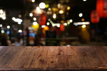 empty dark wooden table in front of abstract blurred boken bankground of restaurant. can used for di