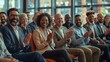 © Munali - A diverse group of professionals claps and smiles during a business event or conference, showcasing engagement and positivity in a modern setting.