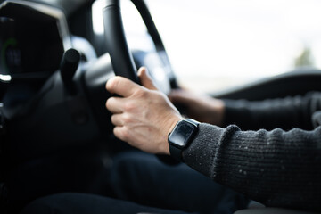 male caucasian hand driving car steering watch jumper destination holiday work