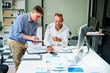 © Phushutter - An Italian male and a Caucasian male sit at business desk in office meeting room, discussing financial terms, investment strategies, managing funds with computer monitor displaying relevant data.