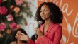 © Nadin Faust - black woman in pink business attire speaking on stage at female entrepreneur event with floral backdrop in candid style