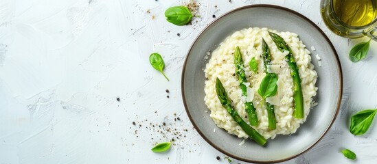 Aufkleber - Top down view of Italian risotto with fresh spring asparagus and parmesan cheese served on a plate against a bright background providing space for additional elements in the image