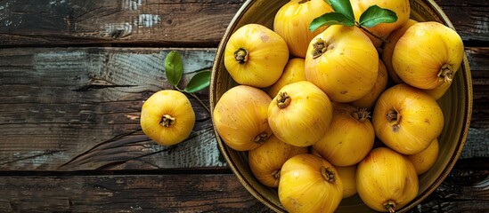 Wall Mural - Close up of delicious ripe quinces in a bowl on a wooden table with copy space image available